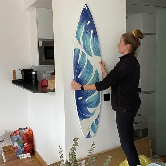 Surfboard with green monstera leaves