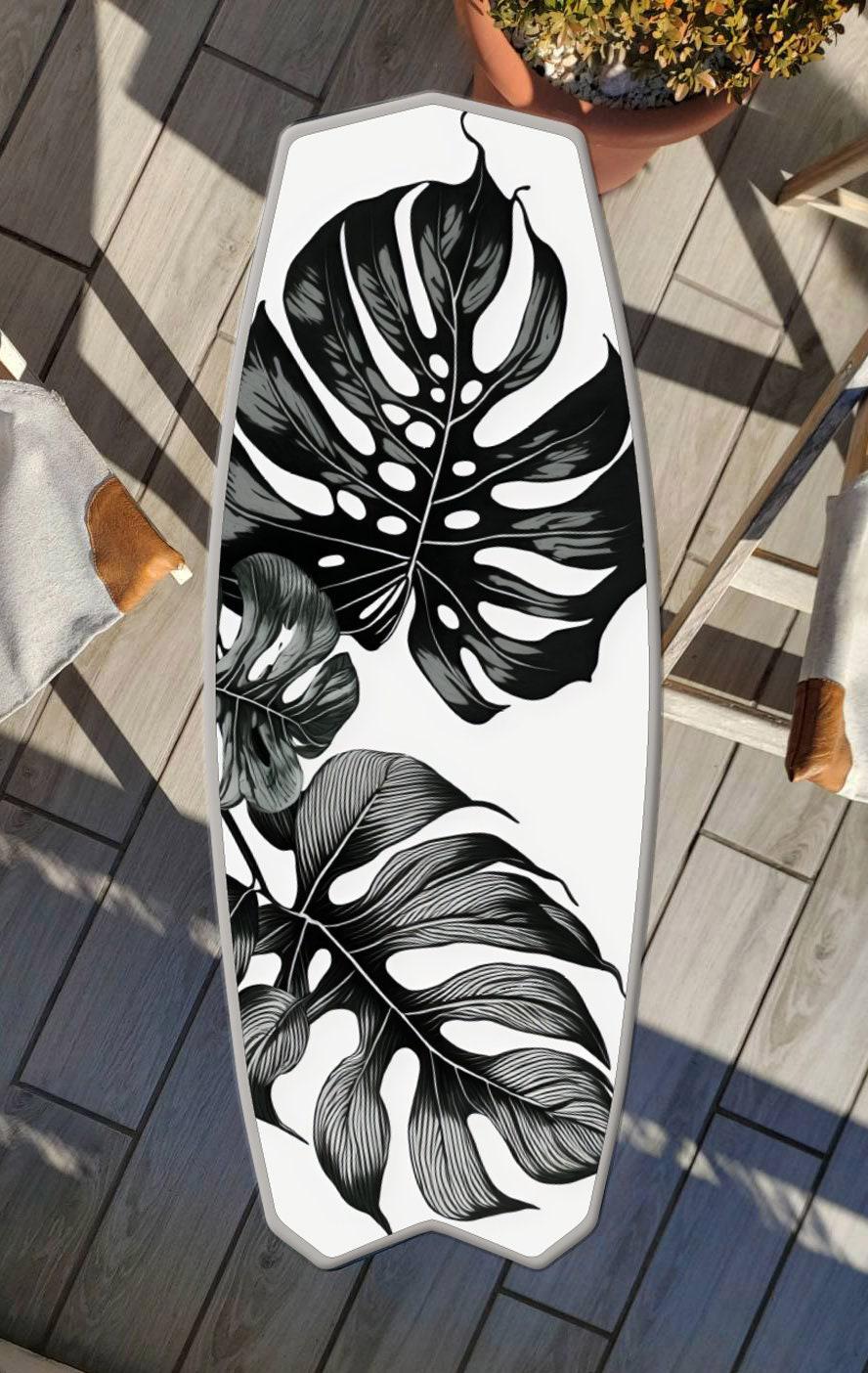 Surfboard shaped coffee table with monstery leaves in black and white design