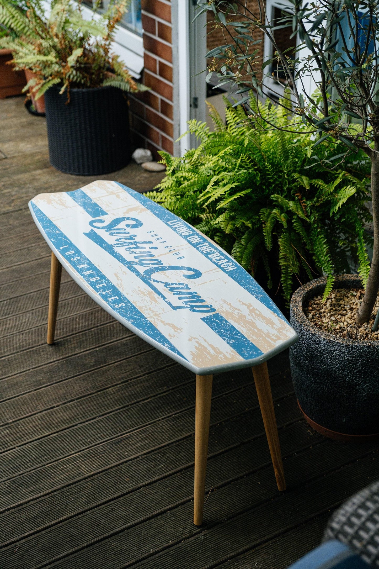 Surfboard shaped coffee table with monstery leaves in black and white design