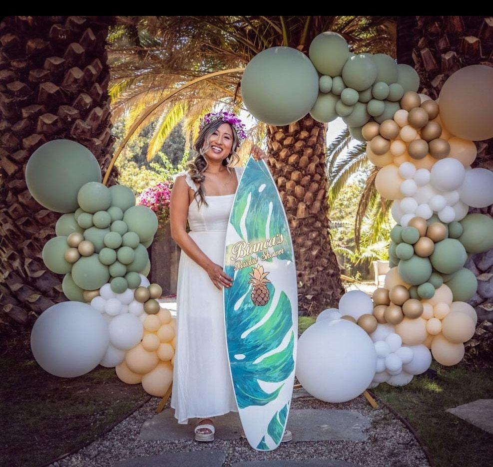 Surfboard with green monstera leaves