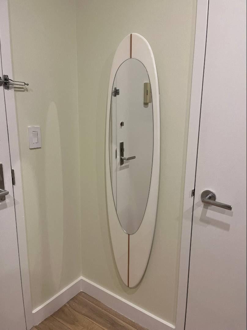 Wall mirror in wooden surfboard shaped frame
