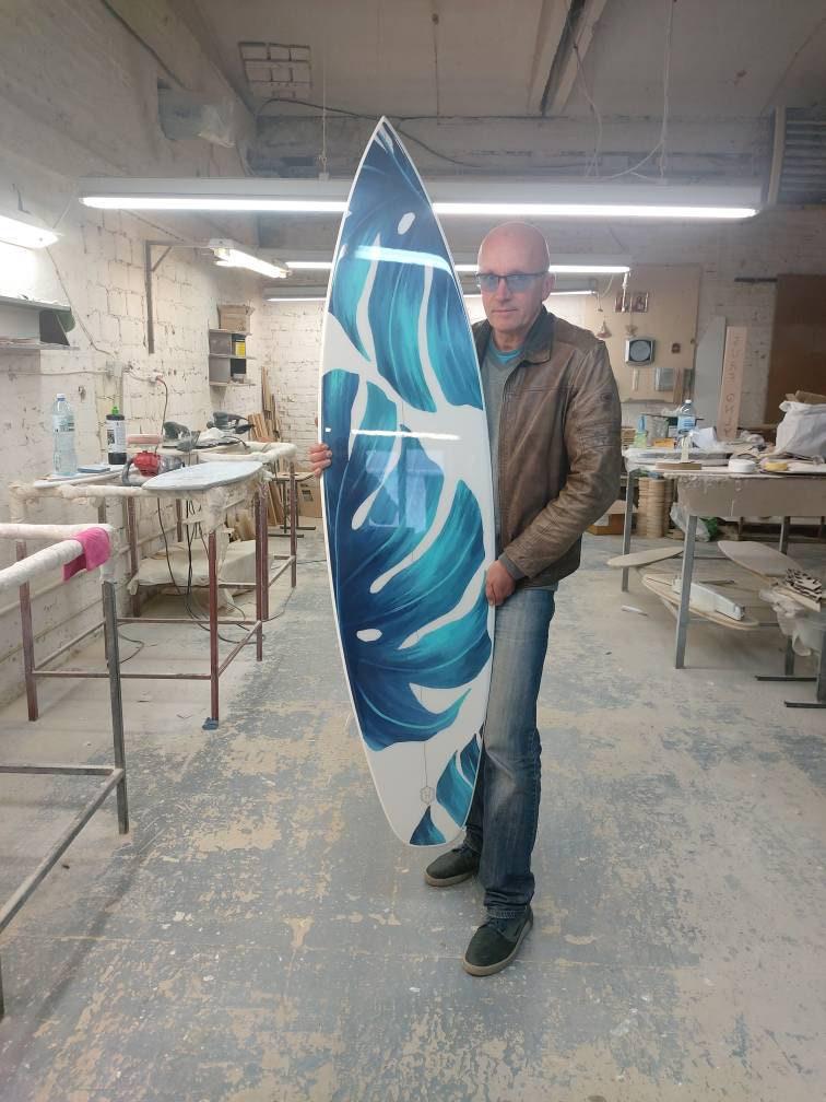 Surfboard with green monstera leaves